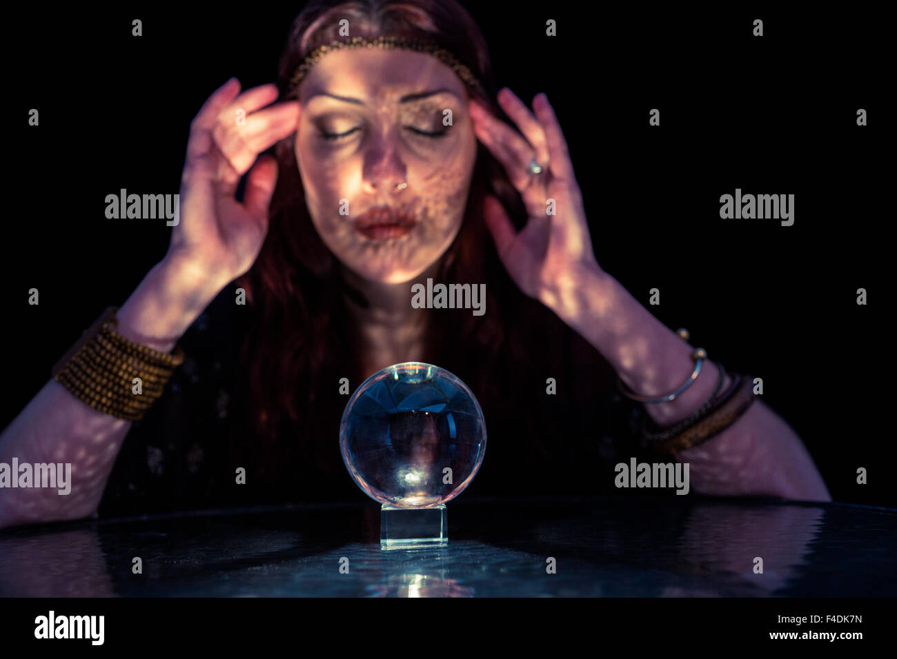 fortune-teller-woman-using-crystal-ball-with-eyes-closed-F4DK7N.jpg